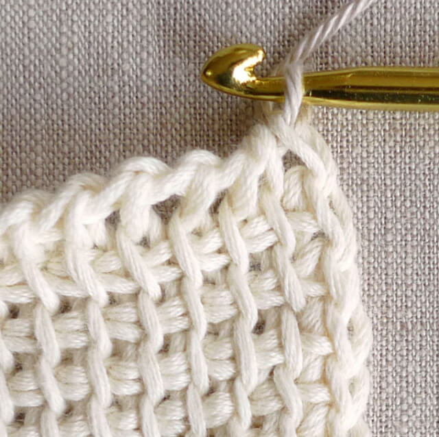 Piece of white wool with crochet needle